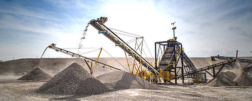 Conveyor belt dumping raw material into piles